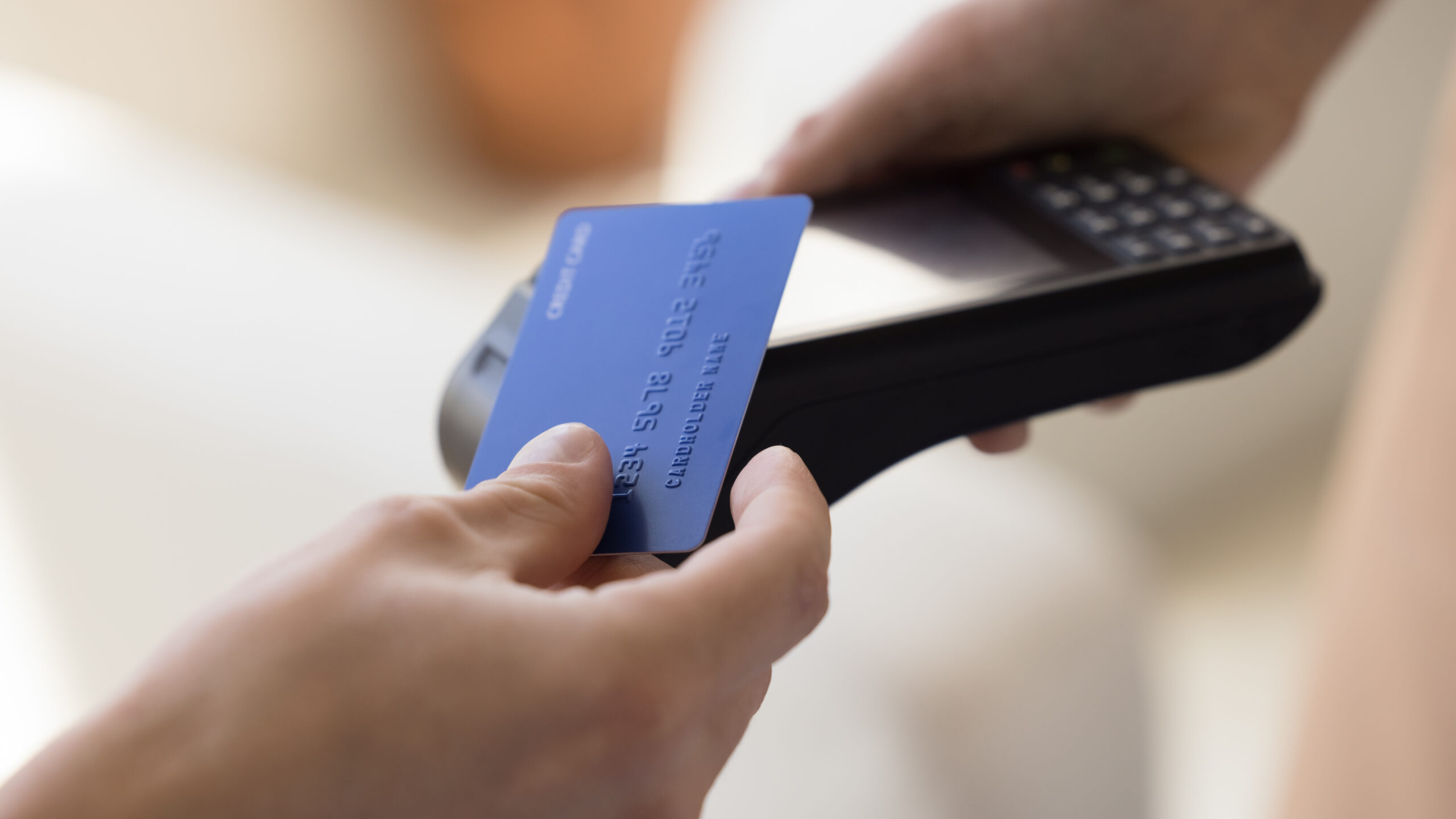 Close up crop view unknown person makes easy, convenient e-payment, holds plastic card against contactless payment terminal equipment, paying for services, food or shopping use wireless NFC technology